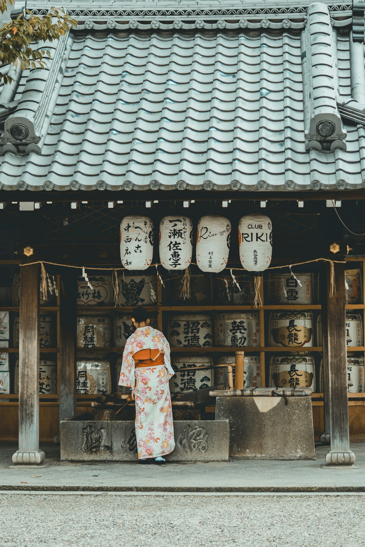 Tourists bowing respectfully at a traditional Japanese shrine gate torii in Kyoto