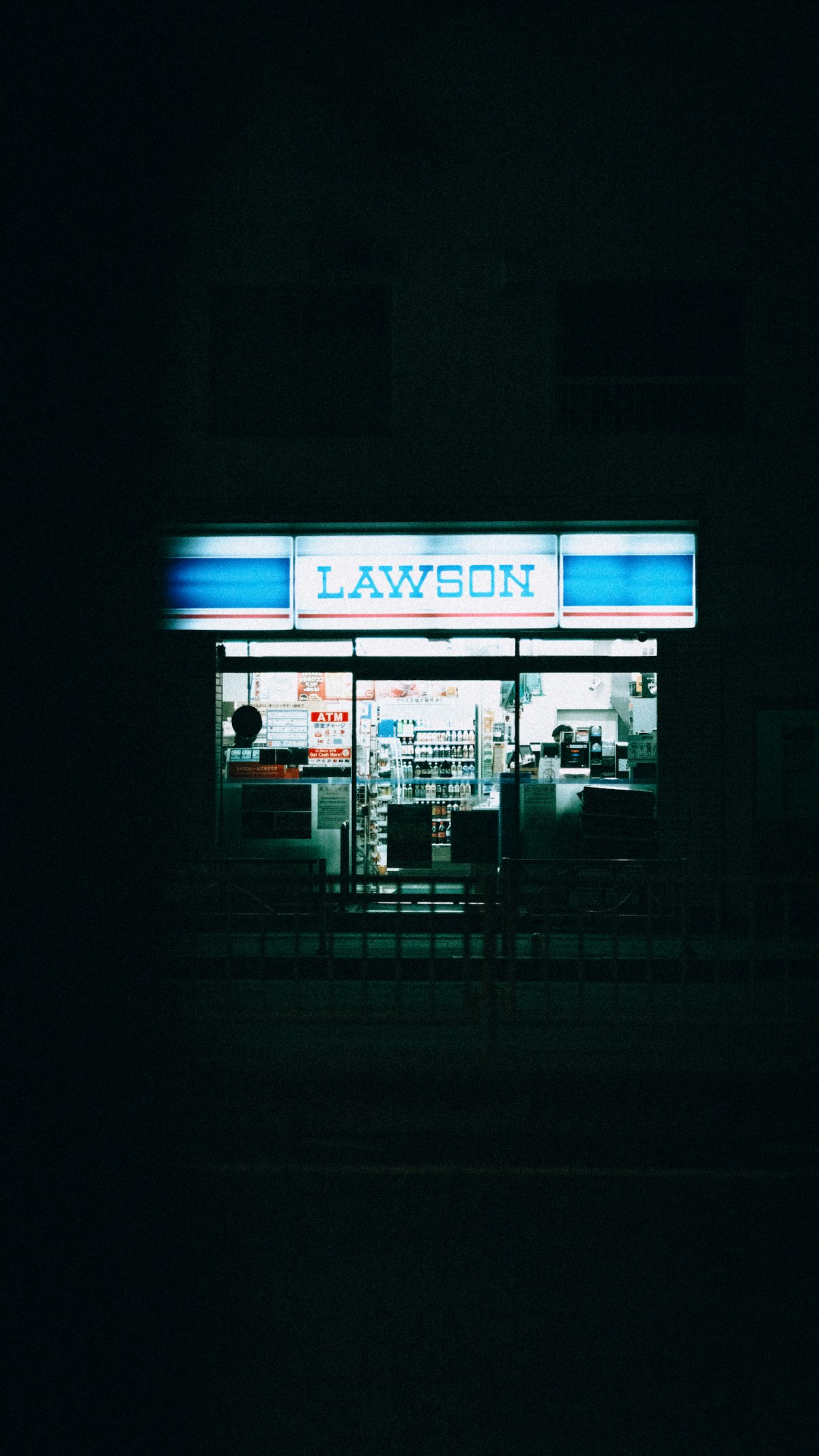 Lawson convenience store illuminated at night in Japan with 7-Bank ATM inside
